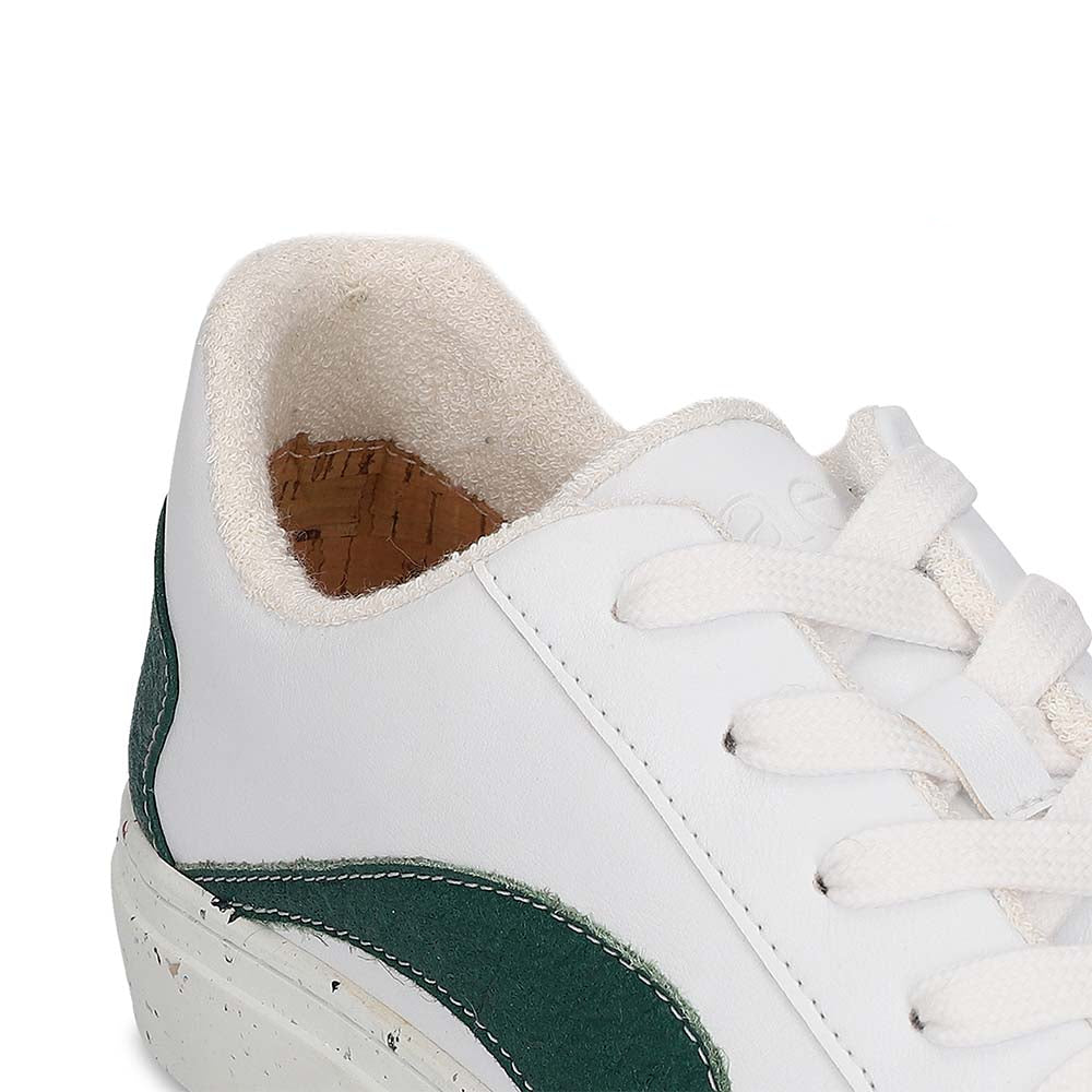 White sneaker with green accents on a white background