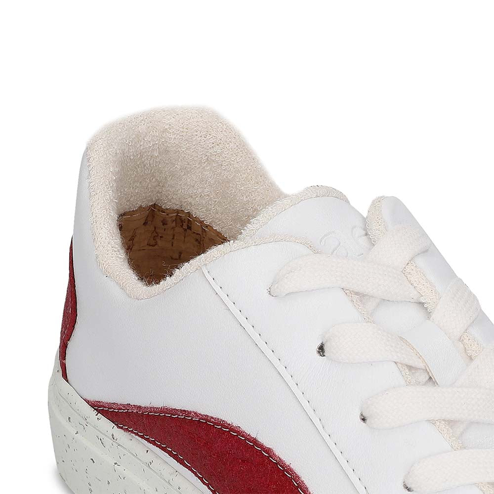 White sneaker with red accent and white laces on a white background, featuring an 'Apple Leather' label.